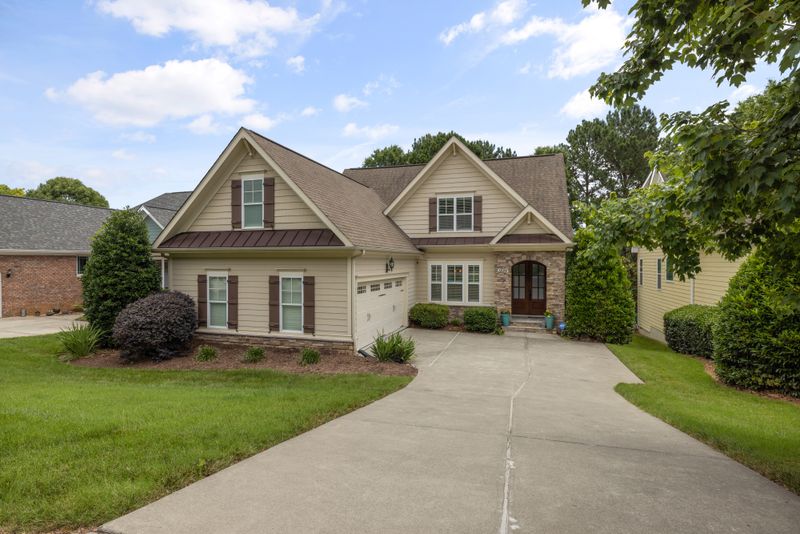 Suburban home with a driveway and mature yard trees